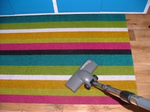 Canister vacuum cleaner: Turbo carpet brush used on kitchen floor mat.