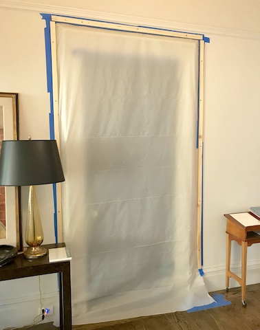 Plastic sheet taped over doorway. To left is lamp on table. To right is music notes on another table.
