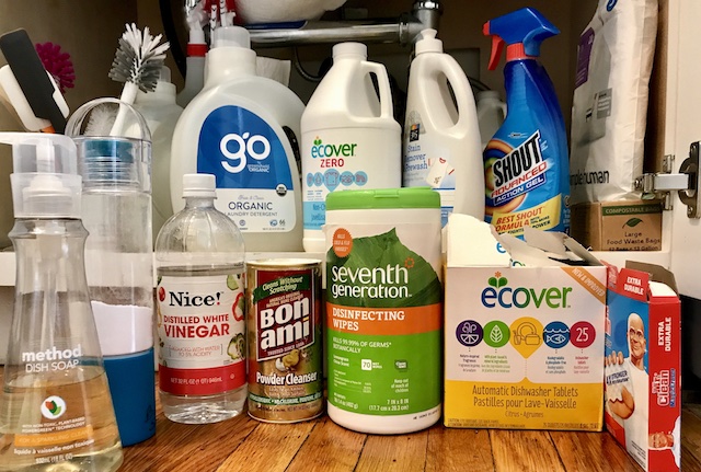 Cleaners. Plus bottle brushes, spatulas, paper towels snd trash bags. Cleaners here: Green Shield Organic Laundry Detergent, Ecover Zero non-Chlorine Bleach; 365 Stain Remover Prewash; Shout stain remover; Mr. Clean Magic Sponge; Ecover Dishwasher Tablets (with unexpected fragrance), Seventh Generation Disinfecting Wipes, Bon Ami Powder Cleanser; Nice! White Vinegar; Arm & Hammer Baking Soda; Method Dish Soap. Hanging are three refillable spray bottles containing Biokleen BacOut Stain and Odor Remover (for pet accidents), vinegar, and water. Please note: As a reminder, these is a transitional set.