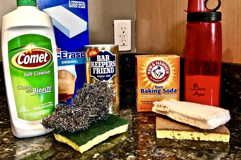 Six scrubbing products on granite kitchen counter top. Grouped together for comparison.